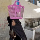 Una mujer palestina transporta botellas de agua. | Reuters